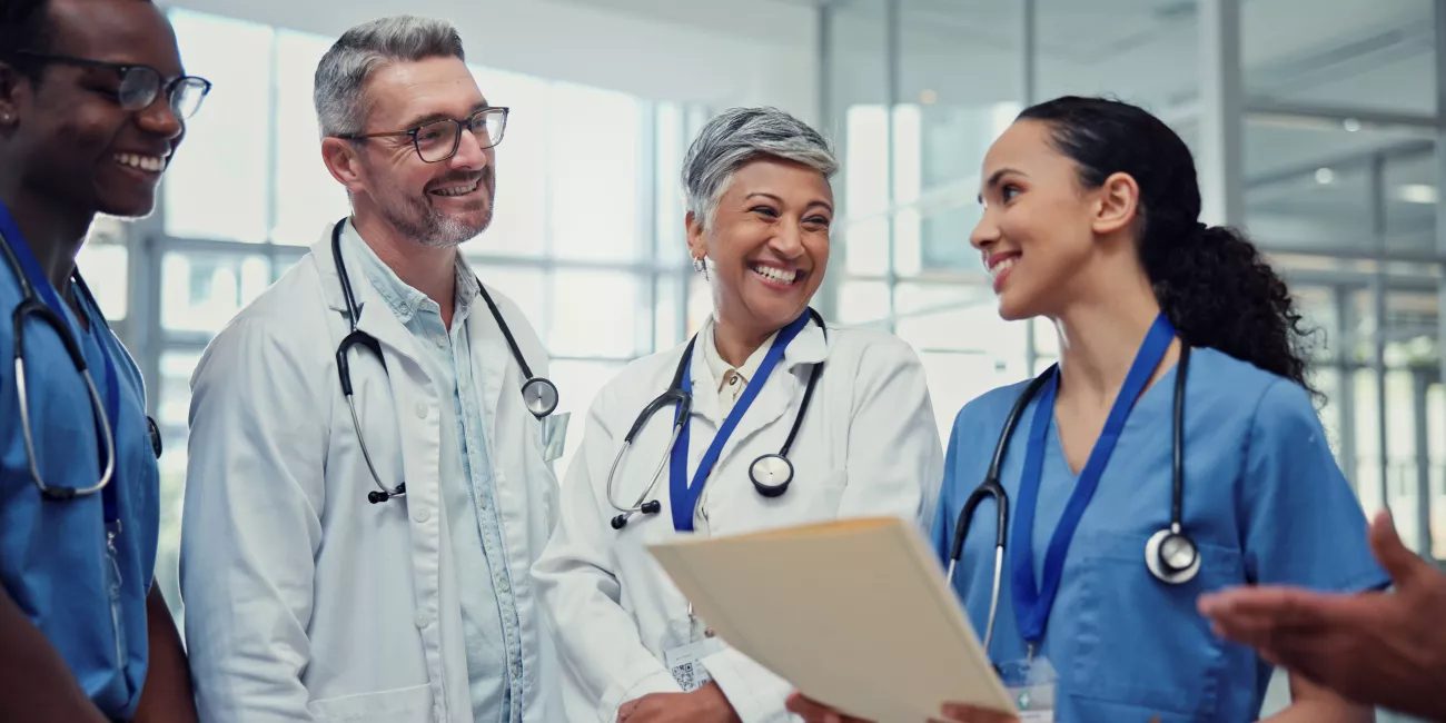 Documents, medical and smile of doctors with nurses in hospital together for collaboration or discussion. Agenda, healthcare and schedule with happy medicine team in clinic for brainstorming 