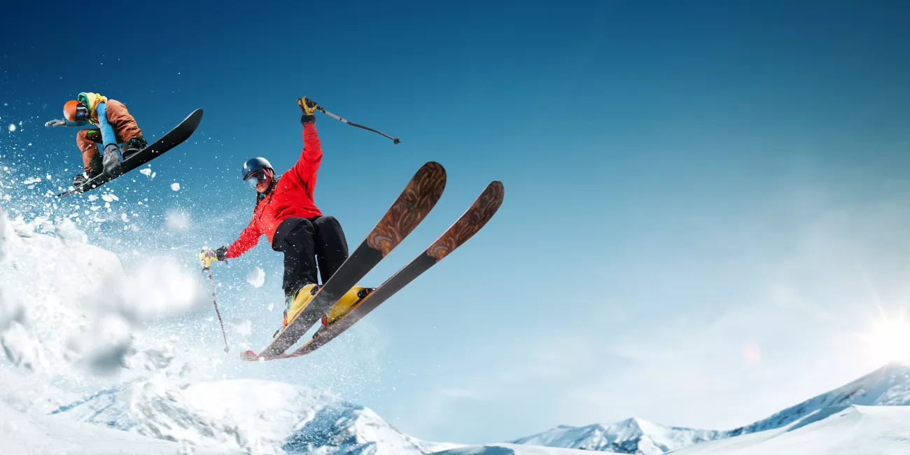 Extreme winter sports. One person skiing and second person snowboarding.