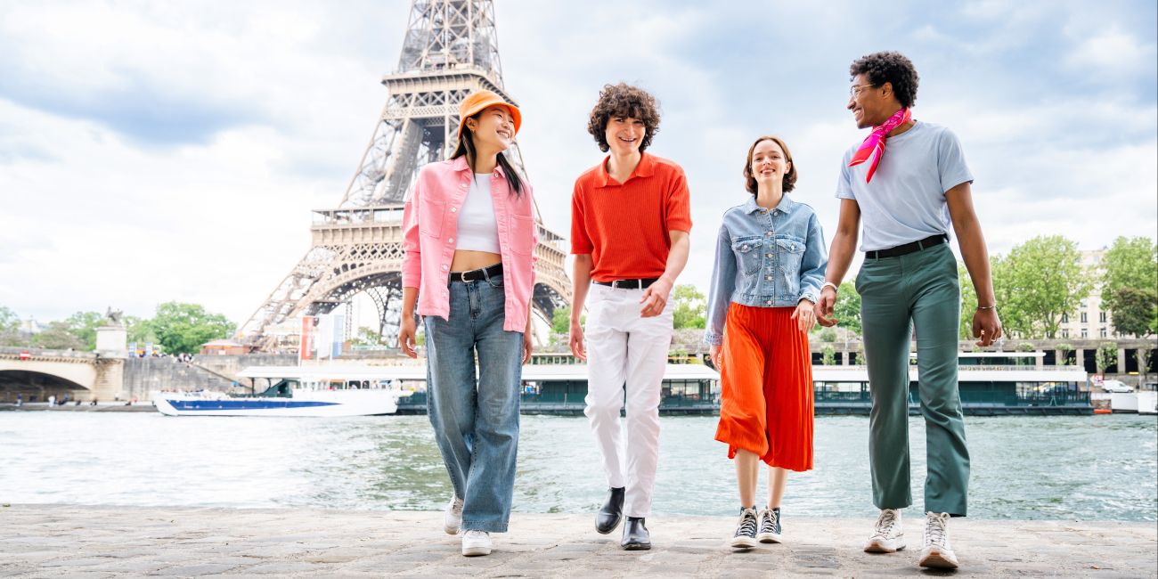 Group of young friends bonding outdoors and having fun sightseeing Paris and Eiffel Tower