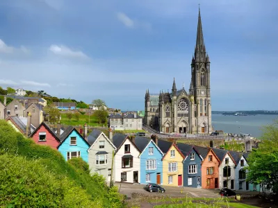 Colorful row houses with St. Colman's Cathedral in background in the port town of Cobh, County Cork, Ireland