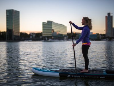 girl on sup board, city view