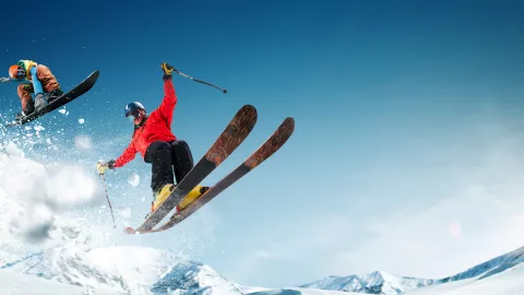 Extreme winter sports. One person skiing and second person snowboarding.