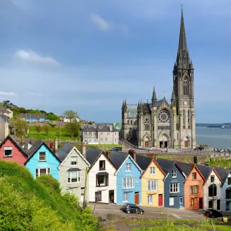 Colorful row houses with St. Colman's Cathedral in background in the port town of Cobh, County Cork, Ireland