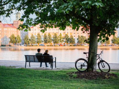 People sitting on the bench by the river